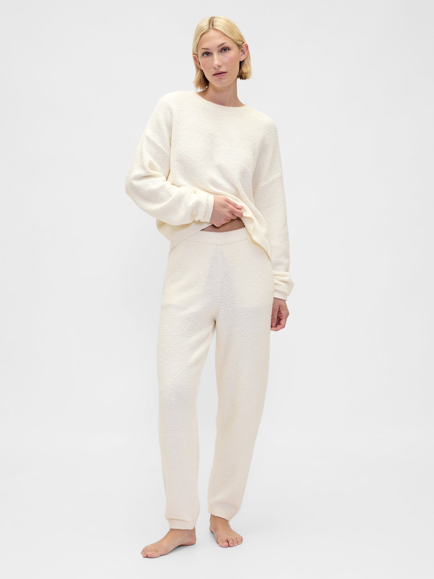 Woman wearing a cream-colored loungewear set on a white background