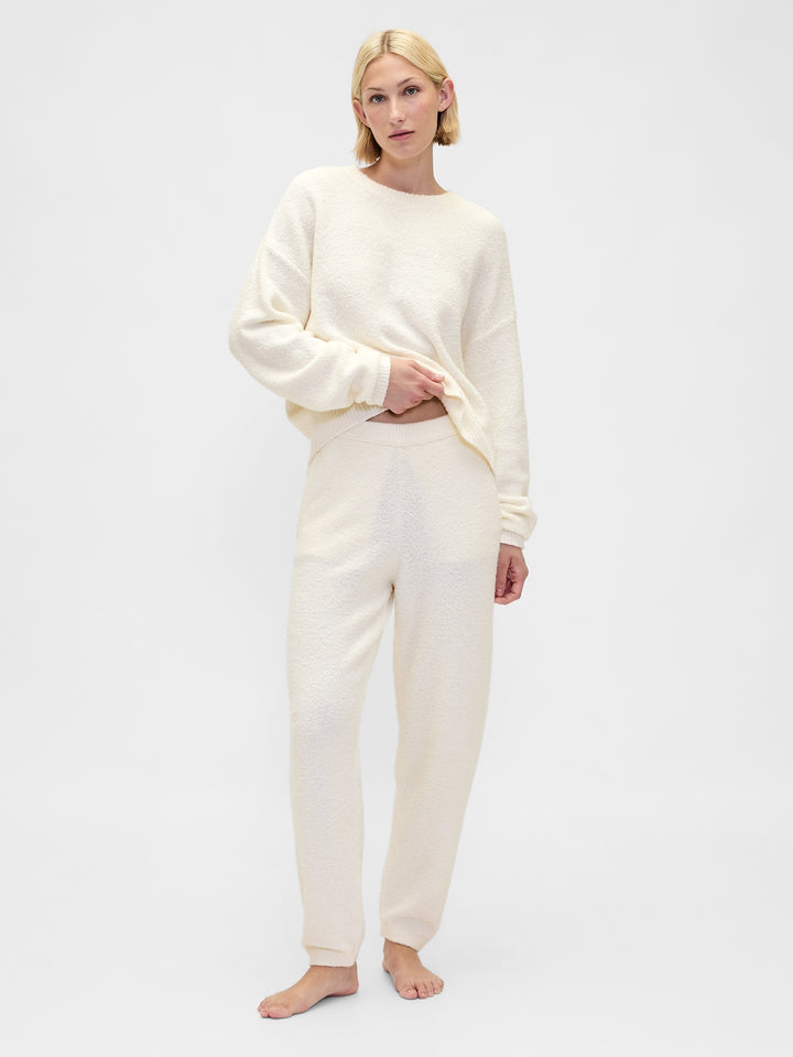 Woman wearing a cream-colored loungewear set on a white background